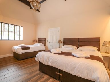A bedroom with two beds bedside lamps and a window at The Five Bells Inn in Upwell
