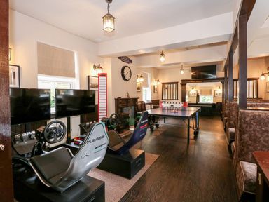 A gaming and entertainment room with racing simulators ping pong table and foosball table at The Five Bells Inn in Upwell