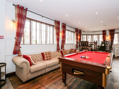 A room with a red pool table beige sofa and plaid curtains at The Five Bells Inn in Upwell