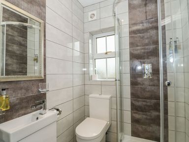 A bathroom with a toilet sink mirror and a glass shower enclosure at The Five Bells Inn in Upwell