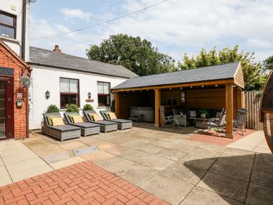 An outdoor patio with lounge chairs and a covered seating area at The Five Bells Inn in Upwell