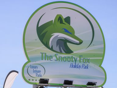A sign for The Snooty Fox Holiday Park with a green fox logo and text Luxury Leisure Parks