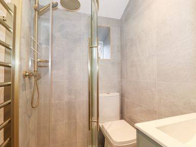 A small bathroom with a shower cubicle and a toilet at Fell View in Ambleside