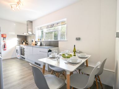 A kitchen with a dining table set for four near a window at Hook Farm Cottage in Uplyme