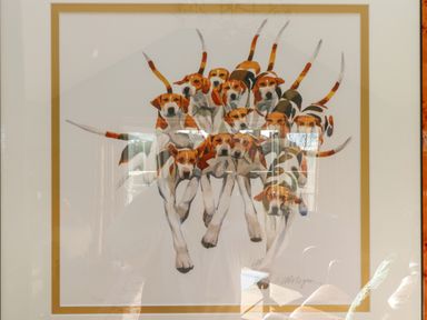 A framed artwork of multiple dogs with raised tails overlapping each other