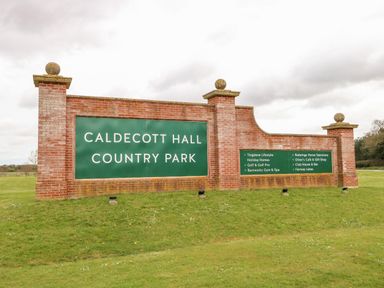 A brick sign for Caldecott Hall Country Park on a grass area