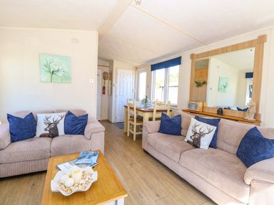 A living room with sofas and a dining area at 25 Foxburrow Hang in Fritton near Belton