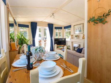A dining room with a table set for meals at 25 Foxburrow Hang in Fritton near Belton