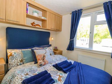 A bedroom with a double bed and shelves at 25 Foxburrow Hang in Fritton near Belton