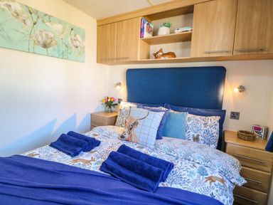 A bedroom with a bed and bedside table at 25 Foxburrow Hang in Fritton near Belton