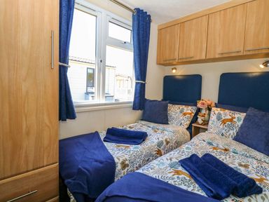 A bedroom with two beds and a window at 25 Foxburrow Hang in Fritton near Belton