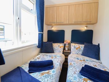A bedroom with two beds and a flower vase at 25 Foxburrow Hang in Fritton near Belton