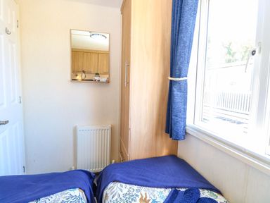A bedroom with beds and a mirror at 25 Foxburrow Hang Fritton near Belton