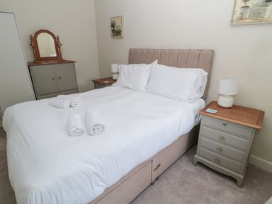 A bedroom with a double bed and bedside tables with lamps at The Haven in North Sunderland near Seahouses
