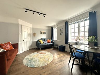 A living room with a sofa and a table at Melanie's Cottage in Brewers Quay Harbour
