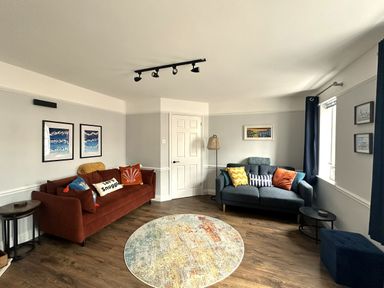 A living room with sofas, a rug and wall art at Melanie's Cottage Brewers Quay Harbour
