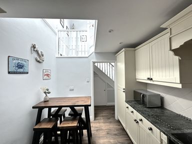 A kitchen with a table and chairs at Melanie's Cottage in Brewers Quay Harbour