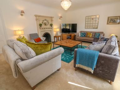 A living room with sofas cushions coffee table fireplace and television at Hindon Hall in Lelant near Carbis Bay
