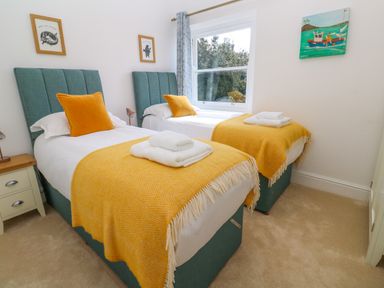 A bedroom with two single beds with yellow blankets and pillows at Hindon Hall in Lelant near Carbis Bay
