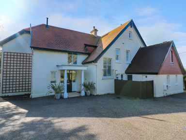 The exterior of a large white house with a tiled roof and a driveway at Hindon Hall Lelant near Carbis Bay
