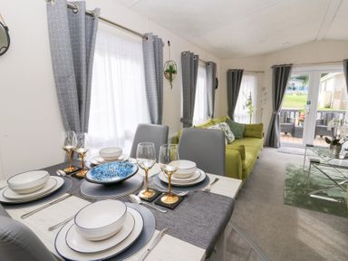 A living room with a dining area and green couch at The Haven in 