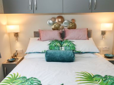 A bed with pillows and decorative plates above in a bedroom at The Haven