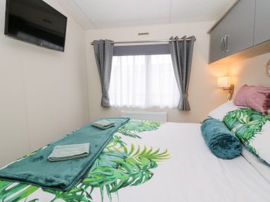 A bedroom with a bed and television at The Haven