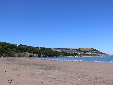 A beach with ocean and cliffs in the background at The Haven 