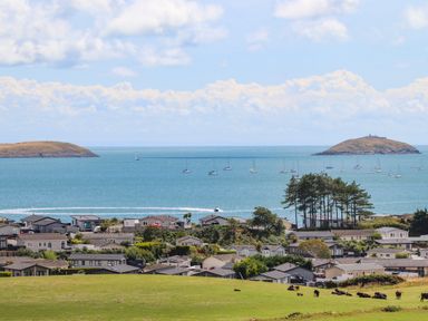 A coastal residential area with houses near the sea and islands in the background at 15 Maes Awel in Abersoch