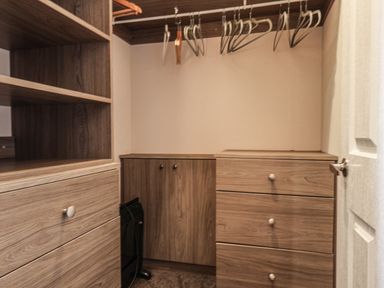 A walk-in closet with wooden shelves drawers cabinets and hangers at Evergreen Pines in Cayton Bay near Scarborough
