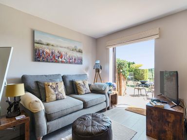 A living room with a sofa and television at Piglet Corner in Culmstock