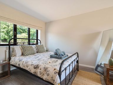 A bedroom with a bed and mirror at Piglet Corner in Culmstock