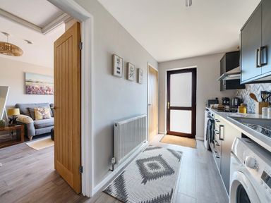 A kitchen with appliances and a door at Piglet Corner in Culmstock