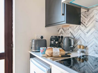A kitchen with appliances and bread on the counter at Piglet Corner in Culmstock