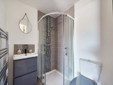 A bathroom with a shower, toilet, and sink at Piglet Corner in Culmstock