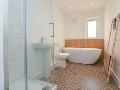 A bathroom with a bathtub toilet sink shower and a towel rack at Valise in Bideford