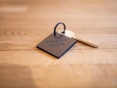 A key with a black keychain reading passing place on a wooden surface at Heisgeir in Sollas Isle Of North Uist