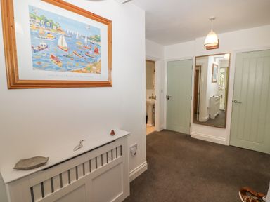 A hallway with two closed doors a large mirror a framed painting and a heater cover at Le Durkestrete Cellar in Haverfordwest