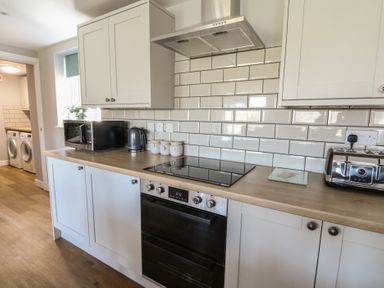 A kitchen counter with microwave kettle jars stove oven and toaster at Curtau Llanfaredd near Builth Wells