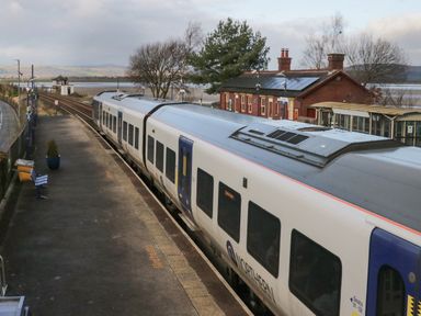 A train parked at a rural railway station with a platform and a small brick building at Time and Tide in Arnside