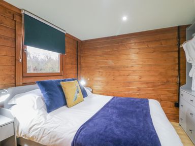 A bedroom with a bed and window at Squirrel's Nest South Luffenham near Edith Weston