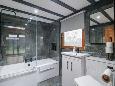 A bathroom with a bathtub, sink, and toilet at Squirrel's Nest in South Luffenham near Edith Weston