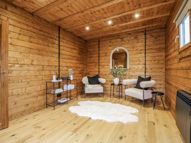 A snug with wooden walls and two sofas at Squirrel's Nest near South Luffenham