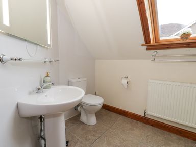A bathroom with a sink and toilet near a window in Y Tylwyth in Blaenau Ffestiniog