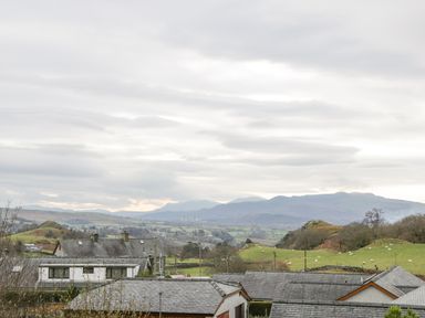 A rural landscape with houses in the foreground and hills with scattered sheep in the background at Y Tylwyth in Blaenau Ffestiniog