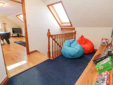 A landing area with two bean bags and board games on a shelf at Y Tylwyth in Blaenau Ffestiniog