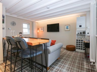 A dining room with a table and chairs at Pine Cottage in Dinas Dinlle