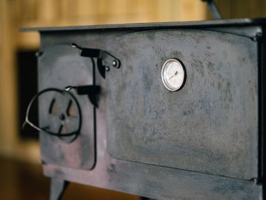 A close-up of a metal wood-burning stove with a temperature gauge and handle at Beech in Dalwood