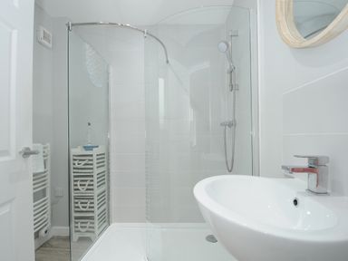 A bathroom with a shower enclosure a sink and a towel rack at Otters Leap in Bideford