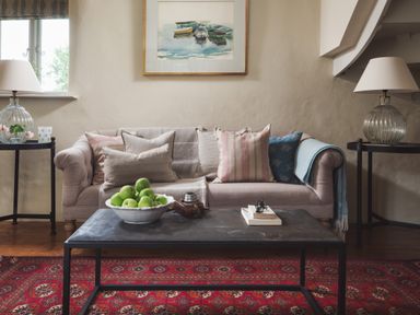 A living room with a sofa pillows and lamps on side tables at Hawthorn Cottage at Collihole in Chagford
